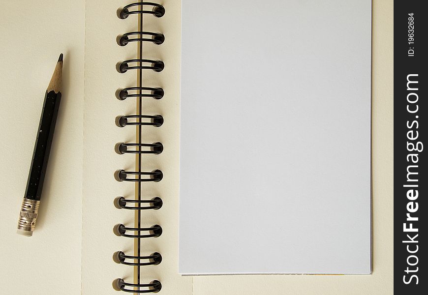 White note paper and black pencil on notebook