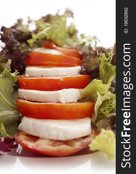 Mozarella and tomatoes on a plate with salad. Mozarella and tomatoes on a plate with salad