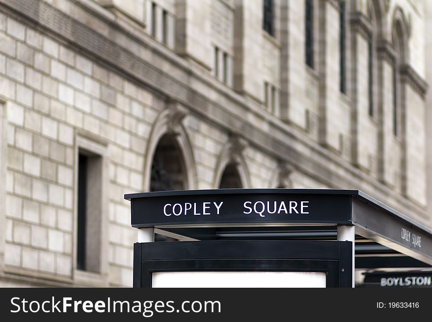 View of the architecture of Copley Square in Boston, Massachusetts - USA. Focus on the Street Sign on the Bus Stop.