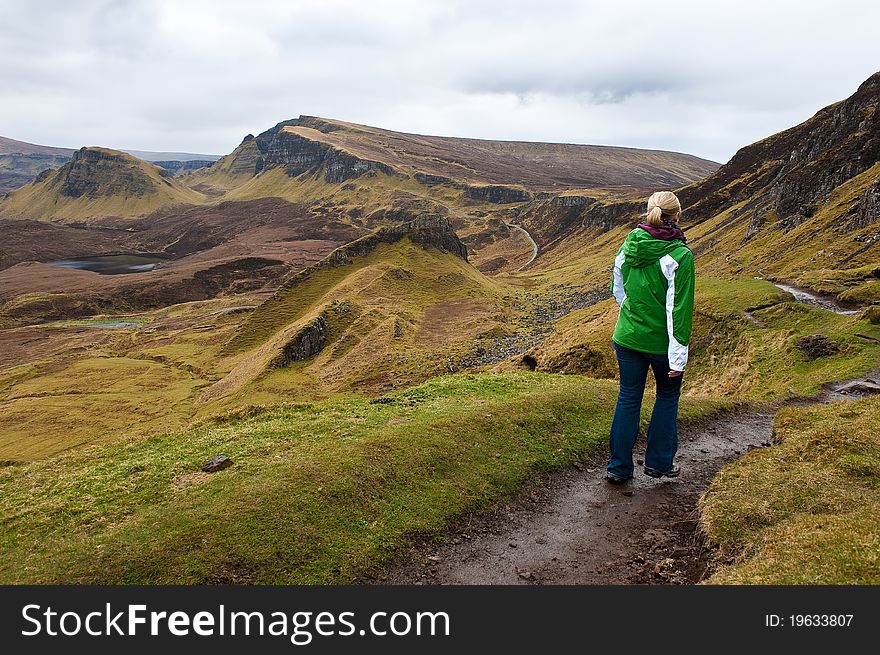 A woman hiking in the Quiraing Mountains on the Isle of Skye in Scotland, United Kingdom. A woman hiking in the Quiraing Mountains on the Isle of Skye in Scotland, United Kingdom.