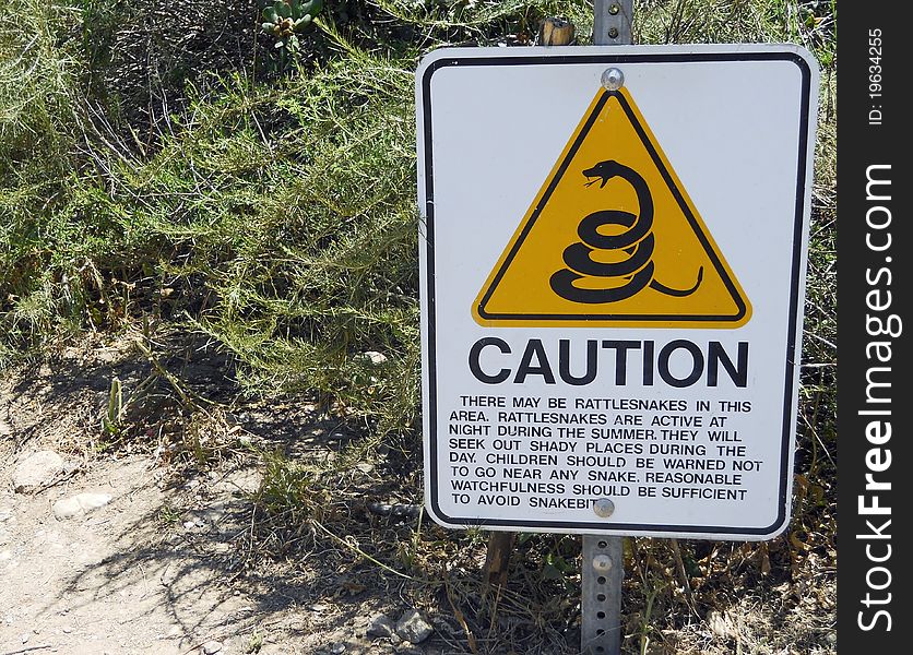 A Caution Sign warns Hikers to be alert for Rattlesnakes. A Caution Sign warns Hikers to be alert for Rattlesnakes.