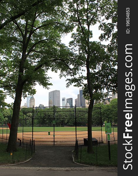 A baseball field in central park with 5th ave in the background. A baseball field in central park with 5th ave in the background