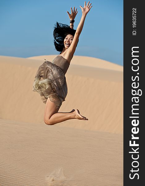 Oung Asian woman Jump on dunes. Oung Asian woman Jump on dunes