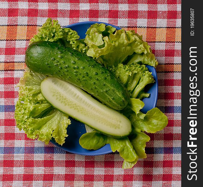 Fresh healthy food - cucumbers and salad on tablecloth