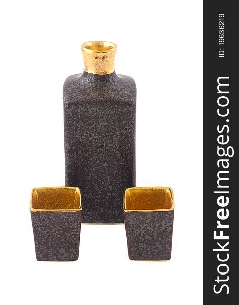 Brown and gold square ceramic sake bottle with two cups isolated on white.