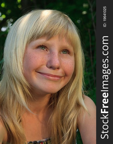 Portrait of the young girl with a smile in a green wood