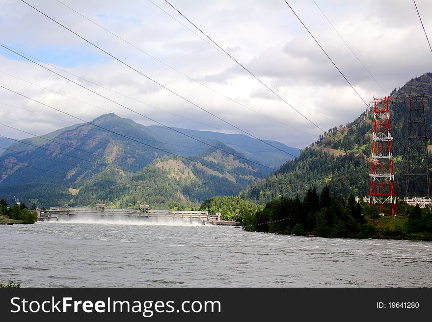 Electric power lines & towers from the Bonneville Dam on the Columbia River. Fluffy clouds in sky, green hillside. Electric power lines & towers from the Bonneville Dam on the Columbia River. Fluffy clouds in sky, green hillside.