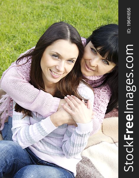 Portrait of smiling mother and teenage daughter hugging in the park happy. Portrait of smiling mother and teenage daughter hugging in the park happy