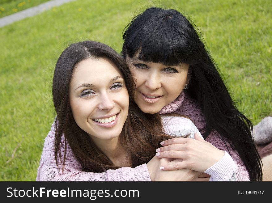 Portrait of smiling mother and teenage daughter hugging in the park happy. Portrait of smiling mother and teenage daughter hugging in the park happy