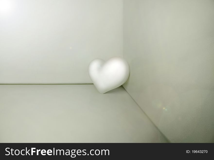 White plastic heart placed in a corner. White plastic heart placed in a corner