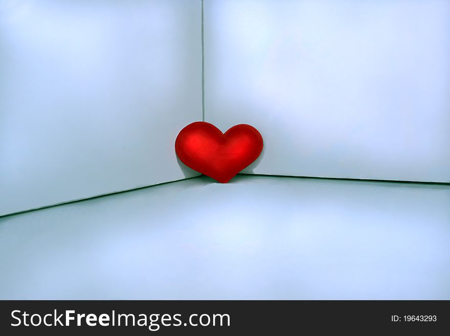 Red heart placed in a corner to light background