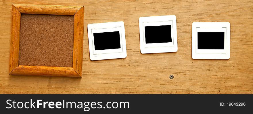 Wooden frame over the wooden plate with 3 slide negative film