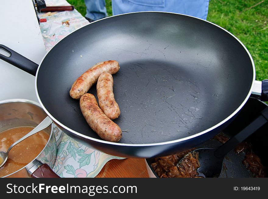 Sausages in frying pan at outdoor market