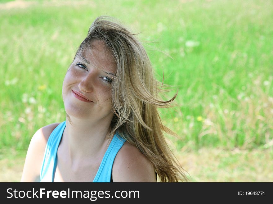 Summer portrait young happy woman against green grass