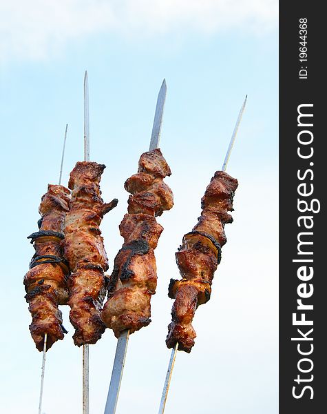 Grilled delicious kebabs over grill of a background