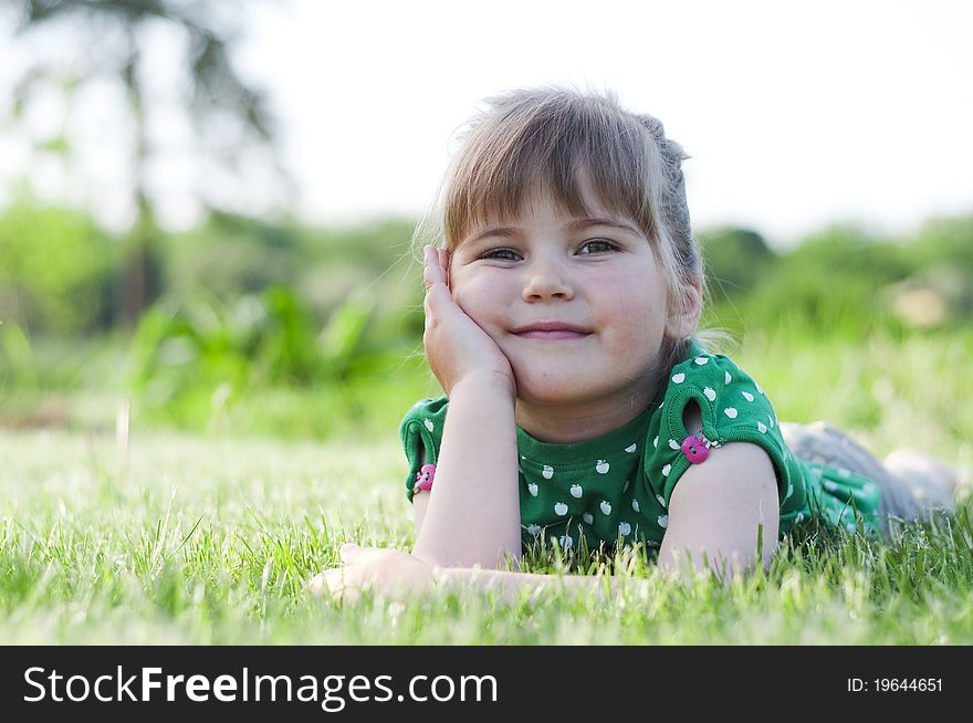 Little adorable girl lying on grass in the park. Little adorable girl lying on grass in the park