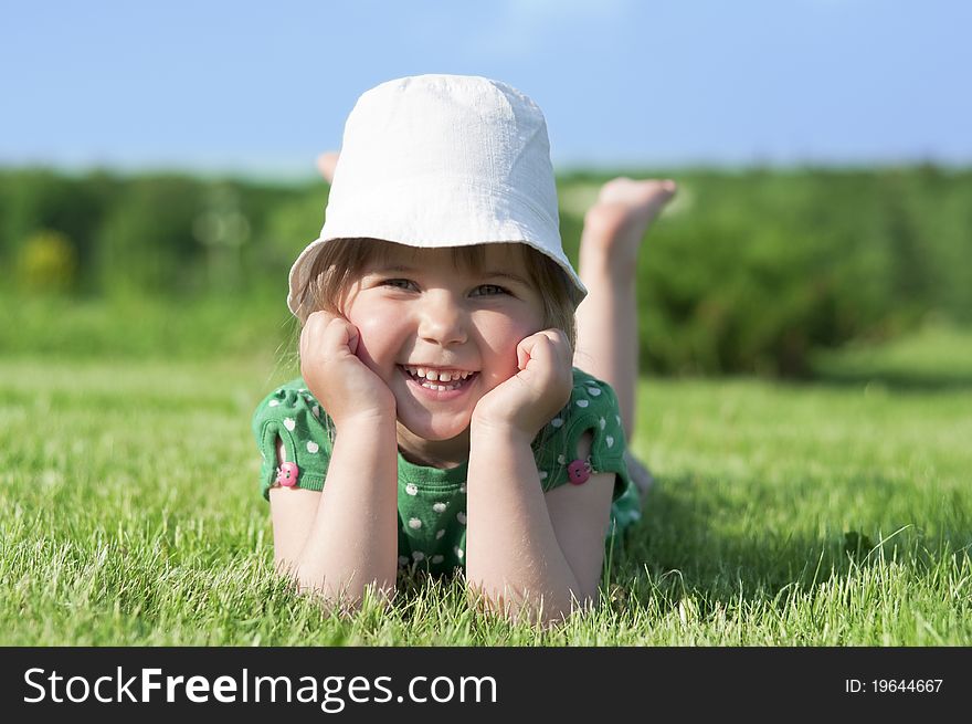 Little adorable girl lying on green grass in park. Little adorable girl lying on green grass in park