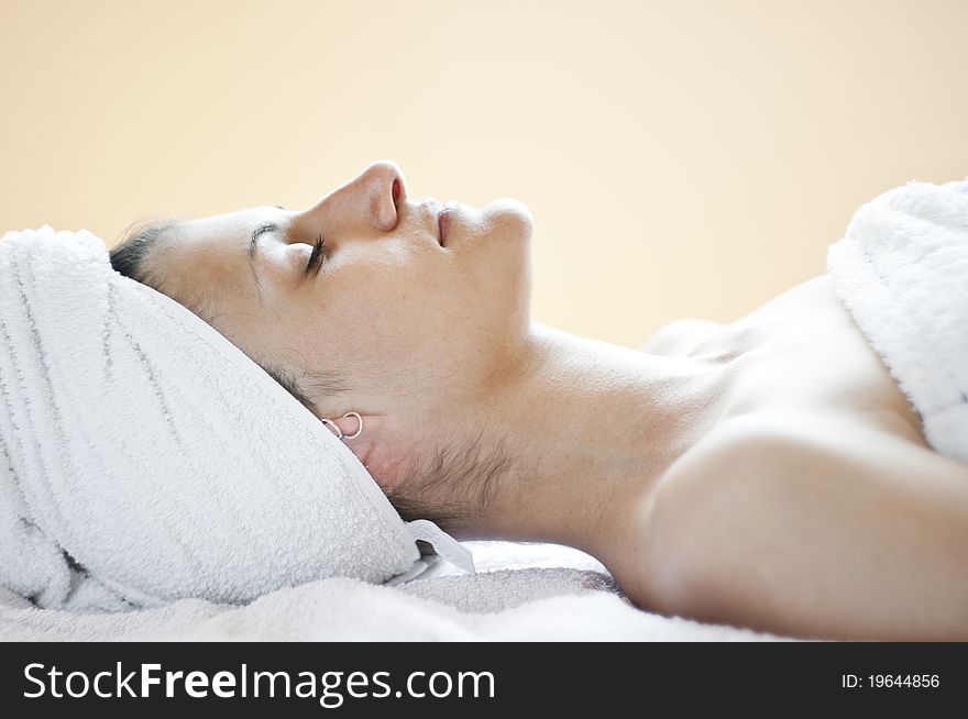 An attractive Caucasian woman lying down on a massage bed. An attractive Caucasian woman lying down on a massage bed