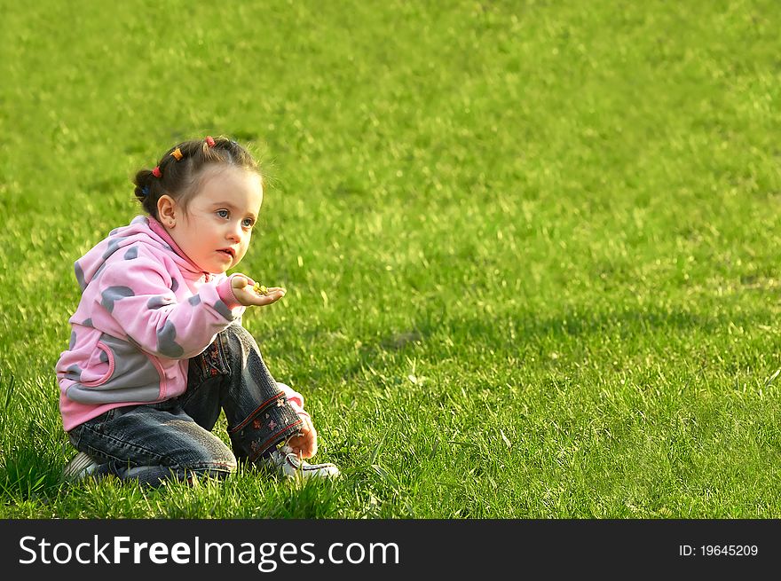 The child a smelling flower in a green grass