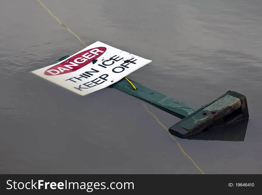 Thin ice sign in a melted pond. Thin ice sign in a melted pond