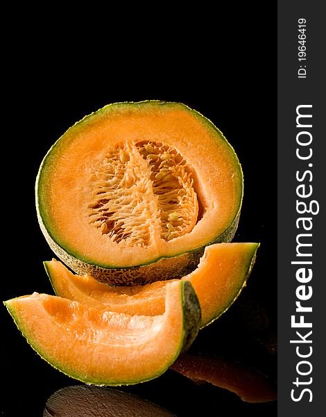 Photo of delicious colorful melon on black isolated background