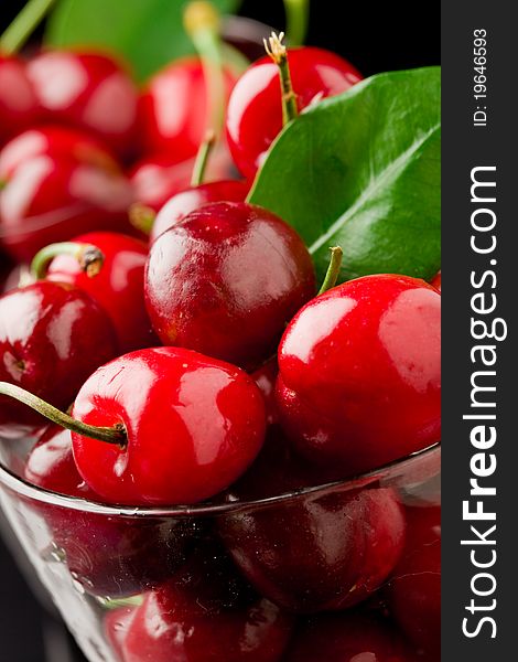 Photo glass with cocktail cherries with green leaves. Photo glass with cocktail cherries with green leaves