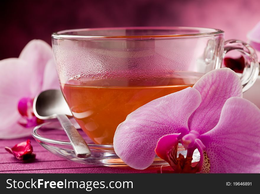 Photo of orchid tea inside a glass cup with big orchid flower