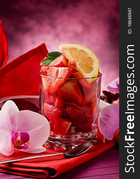 Photo of delicius cutted strawberries with sliced lemon and orchid flower. Photo of delicius cutted strawberries with sliced lemon and orchid flower