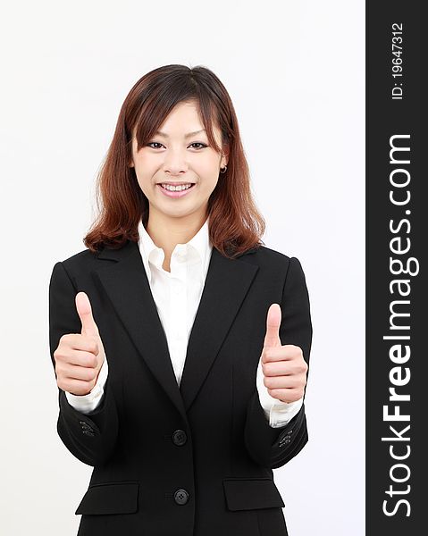 Smiling young japanese business woman showing thumbs up gesture. Smiling young japanese business woman showing thumbs up gesture