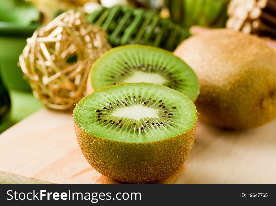 Photo of delicious kiwi on cutting board with decorations around. Photo of delicious kiwi on cutting board with decorations around