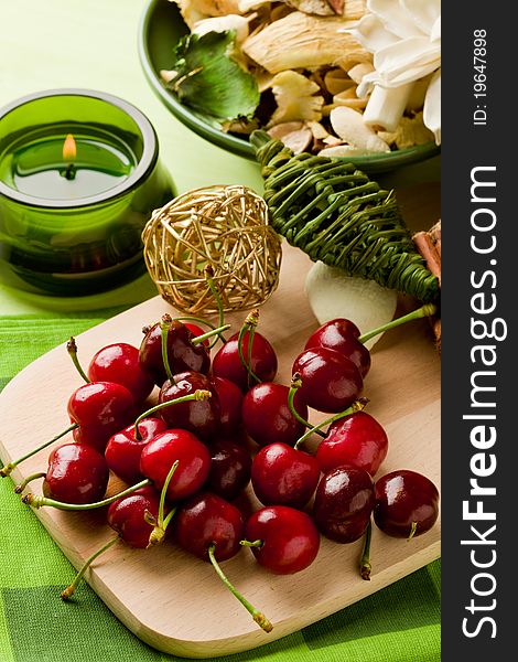 Photo of delicious cherries on cutting board with decoration around. Photo of delicious cherries on cutting board with decoration around