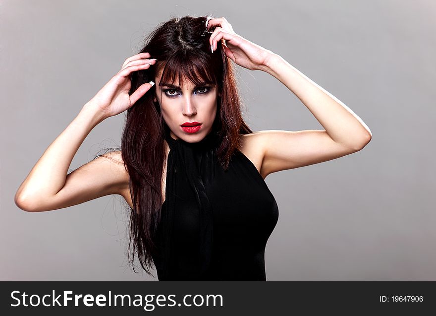 Attractive brunette in a small black dress, posing. Attractive brunette in a small black dress, posing