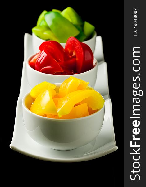 Photo of colorful pepper inside three small bowls on black isolated background. Photo of colorful pepper inside three small bowls on black isolated background