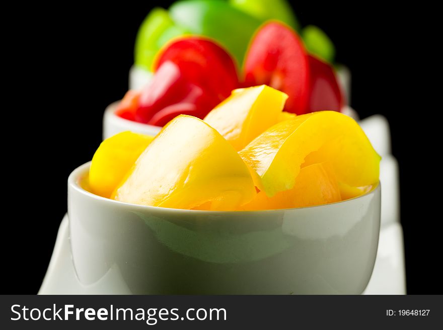 Photo of colorful pepper inside three small bowls on black isolated background. Photo of colorful pepper inside three small bowls on black isolated background