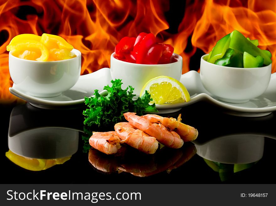 Photo of king prawns on black glass table with flames. Photo of king prawns on black glass table with flames