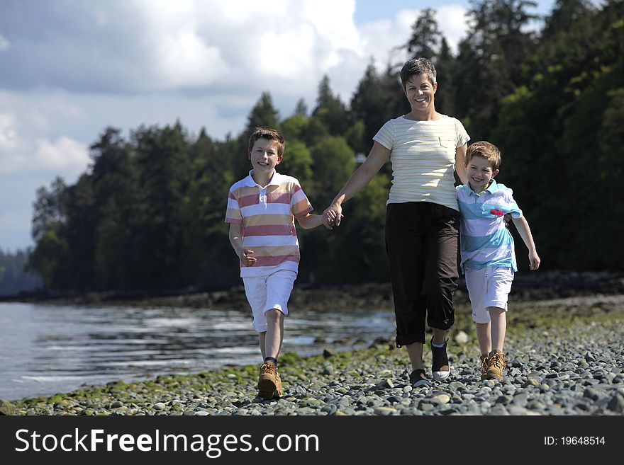 Mother walking with two boys on a beach. Mother walking with two boys on a beach