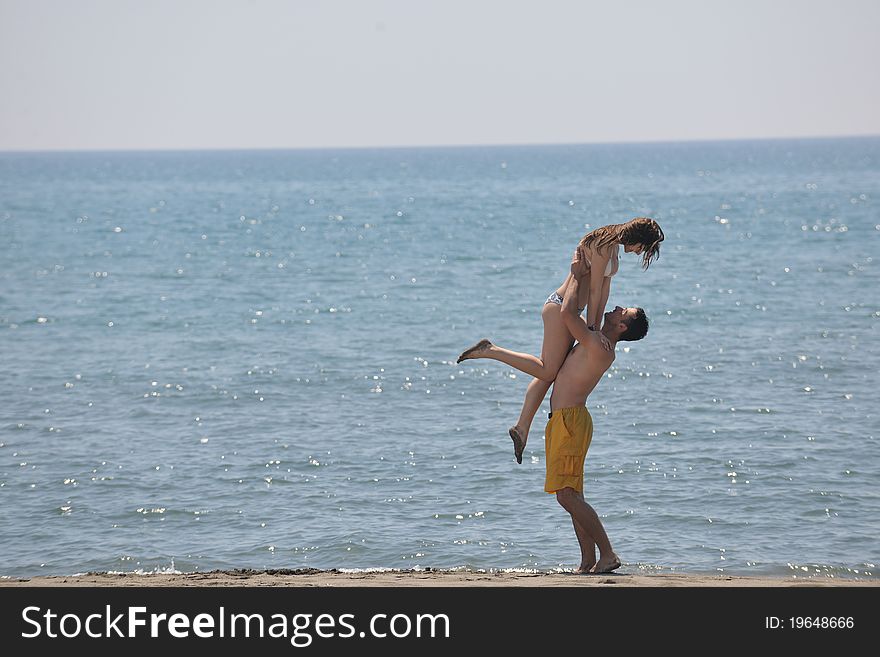 Happy young couple have fun and romantic moments on beach at summer season and representing happynes and travel concept. Happy young couple have fun and romantic moments on beach at summer season and representing happynes and travel concept