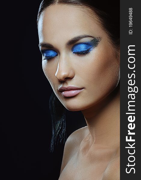 Beautiful girl with blue make-up in long earrings. Beautiful girl with blue make-up in long earrings