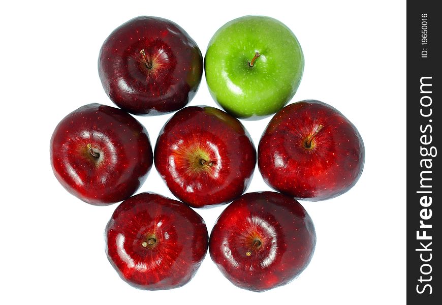 A green apple put among red apples isolated on white background. A green apple put among red apples isolated on white background.