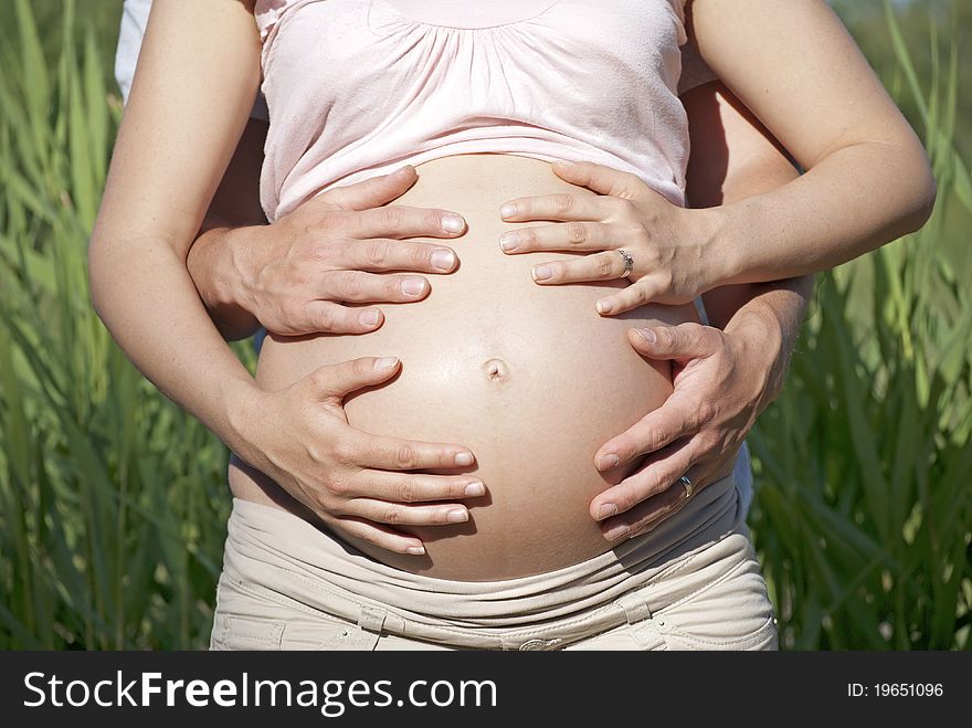Hands covering pregnant belly - bonding. Hands covering pregnant belly - bonding