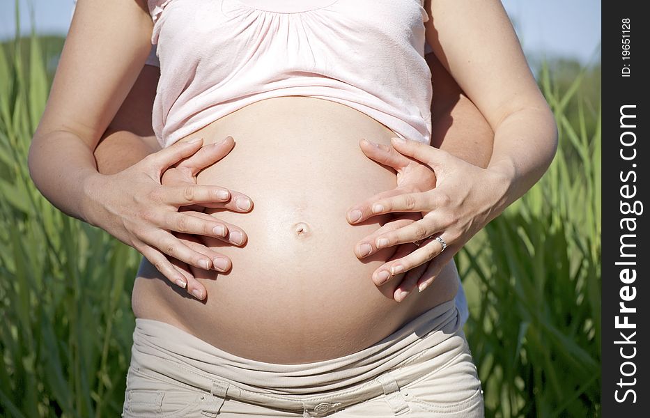 Hands covering pregnant belly - bonding. Hands covering pregnant belly - bonding