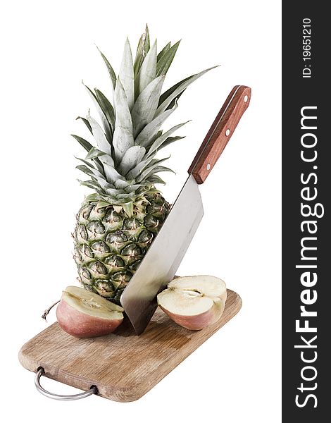 Apple and pineapple on desk with knife, white background