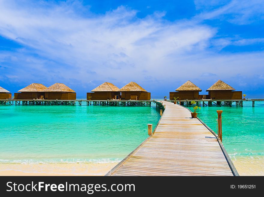 Water bungalows at a tropical island - travel background. Water bungalows at a tropical island - travel background