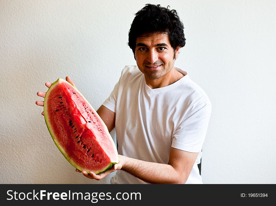 Man smiling and holding a big slice of watermelon. Man smiling and holding a big slice of watermelon