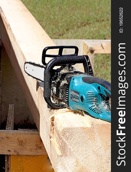 A chain saw and wood on the building site