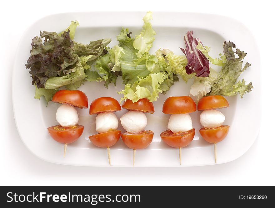 Mozarella and tomatoes on a plate with salad. Mozarella and tomatoes on a plate with salad