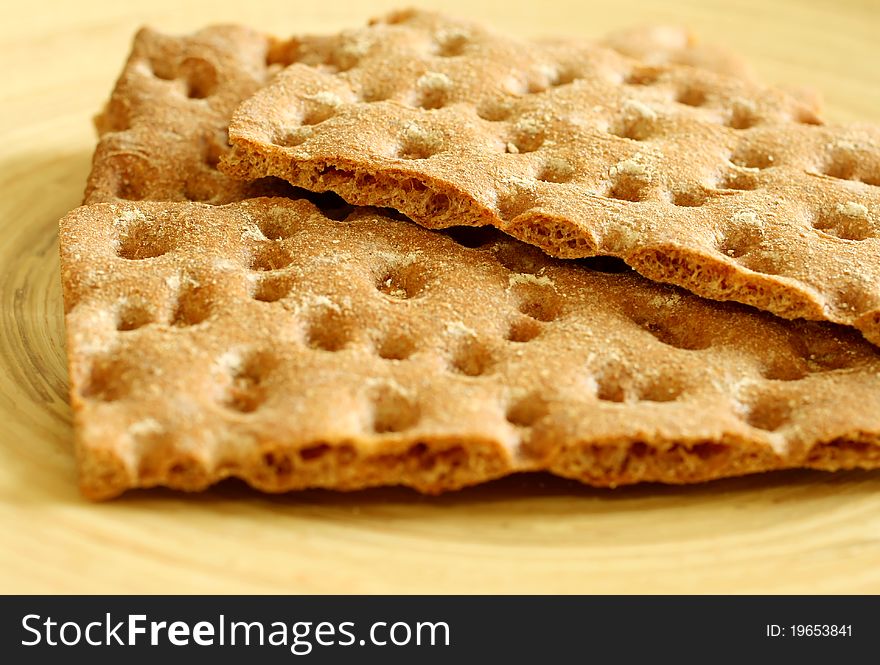 Diet crackers on a wooden plate. Diet crackers on a wooden plate