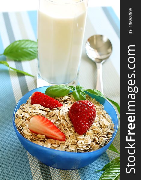 Oats and strawberry in bowl and glass of milk