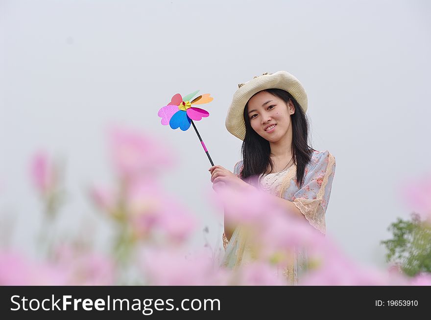 A girl in garden with pinwheel in hand. A girl in garden with pinwheel in hand
