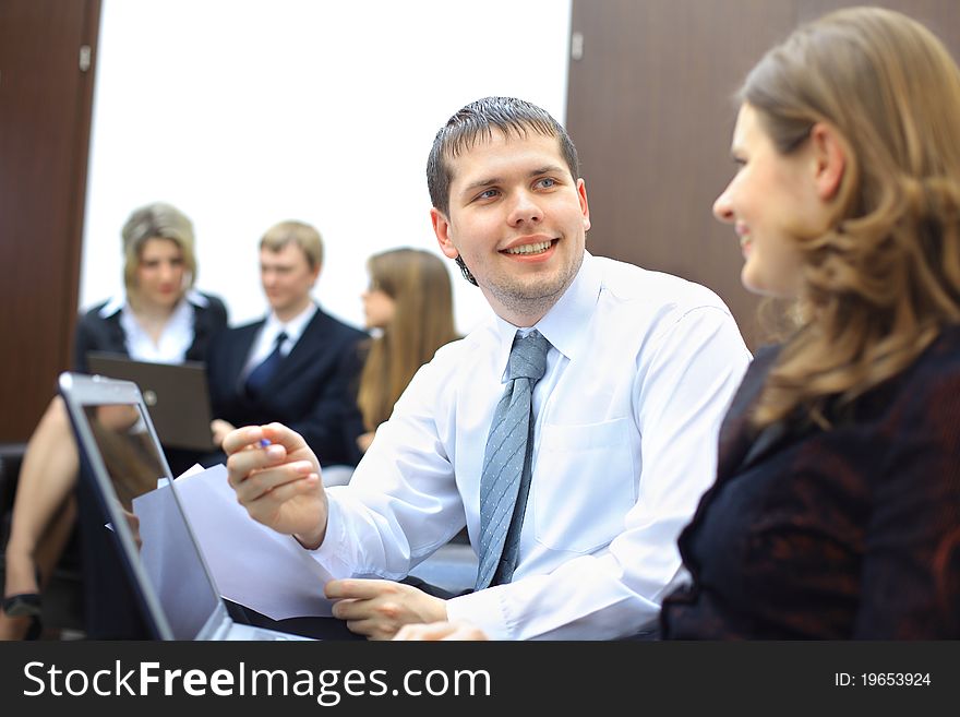 Colleagues sitting at table and discussing during business meeting